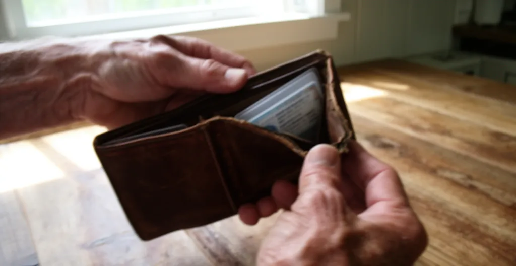 Mains ouvrant un portefeuille contenant une carte d'identité